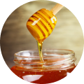 a jar of honey with a wooden spoon next to it