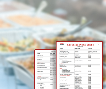 A catering price sheet in focus with food trays blurred in the background