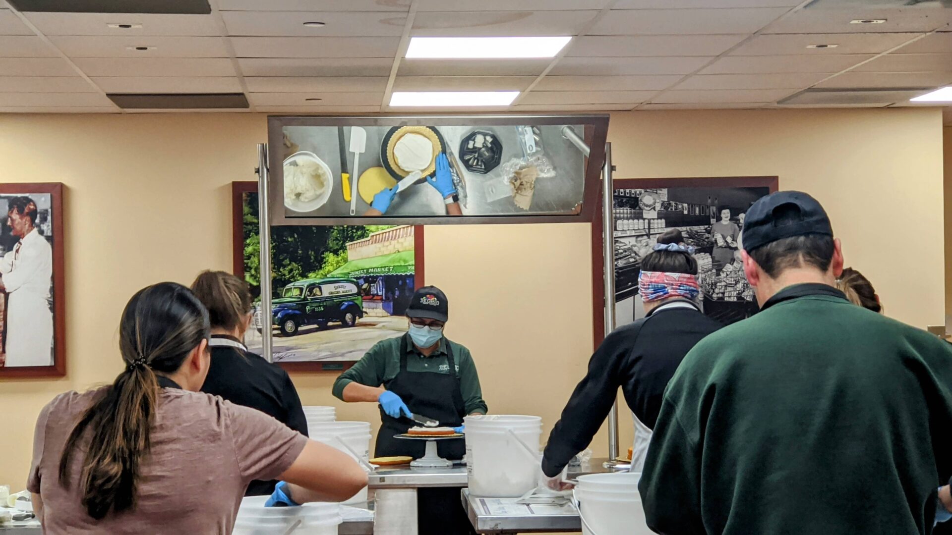 a group of people in a restaurant kitchen preparing food with posters on the wall