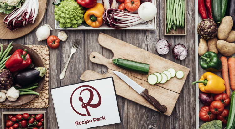 Fresh vegetables on a wooden table with a cutting board, knife, and "Recipe Rack" book at Sunset