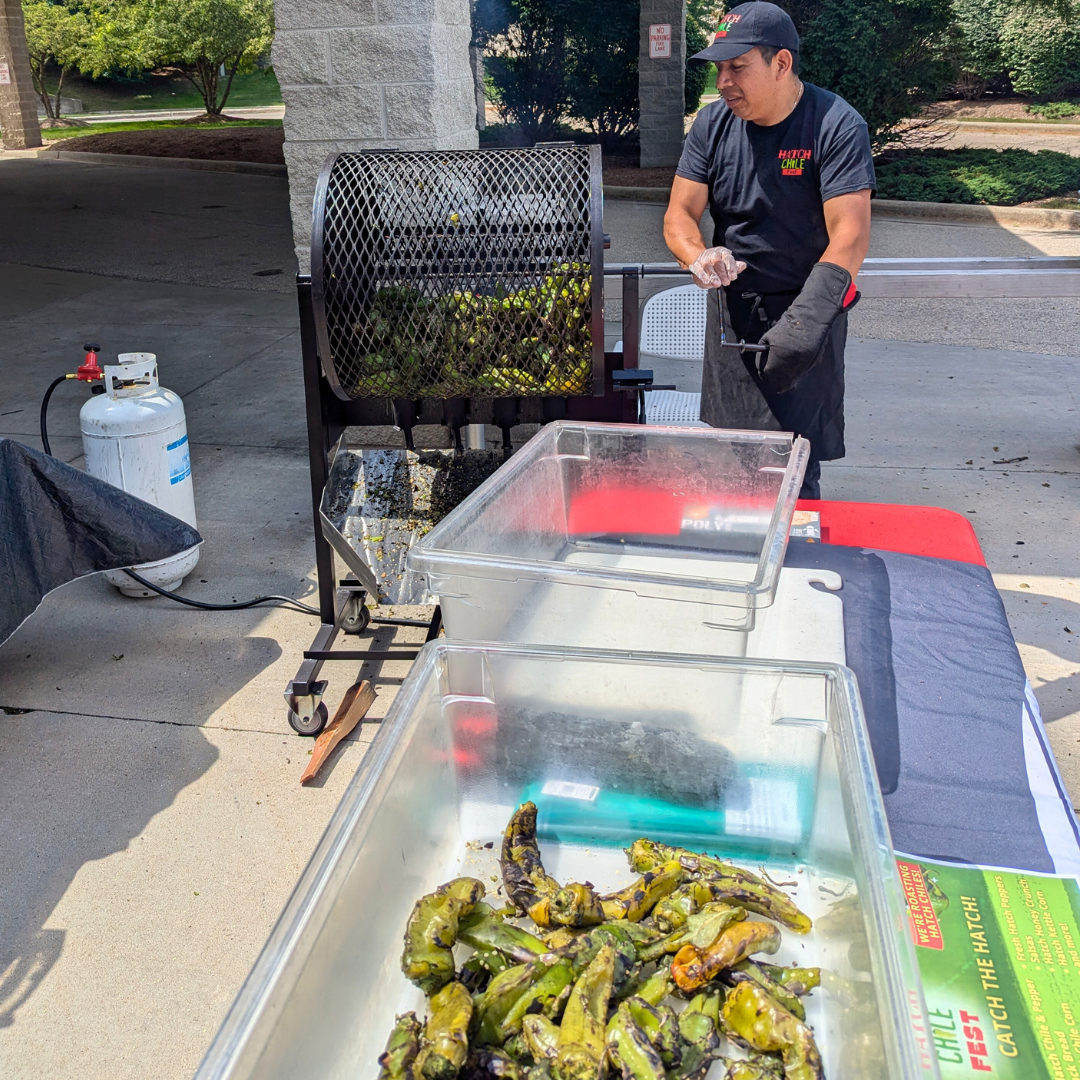 Fresh Hatch chiles being roasted in a large drum roaster.