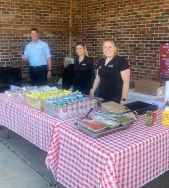 a group of people standing around a table with food on it