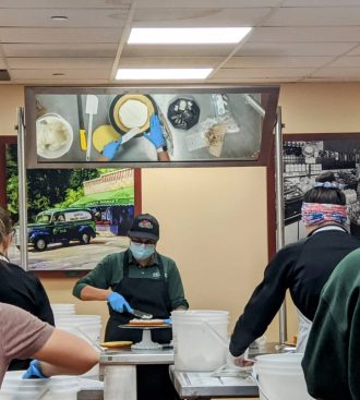 a group of people in a restaurant kitchen preparing food with posters on the wall